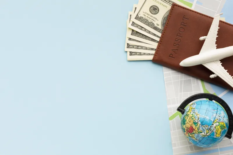 a wallet with money, an airplane and a globe